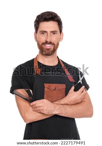 Smiling hairdresser holding combs and scissors on white background