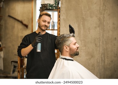 Smiling hairstylist applying cologne or fixing spray on client's haircut - Powered by Shutterstock