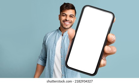 Smiling Handsome Arab Guy In Casual Showing Mobile Phone With White Blank Screen For Advertisement, Recommending Mobile Dating Application, Panorama With Free Space, Mockup, Colllage - Shutterstock ID 2182934327