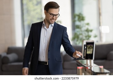 Smiling handsome businessman in suit swipe pass card to electronic reader, opening automatic gates, passing security system checkpoint leaves modern office area after working day. Door access, workday - Powered by Shutterstock