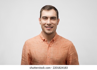 Smiling Handsome Caucasian Man About 30 Years Old In Orange Shirt On White Background, Male Portrait