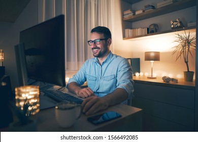 Smiling handsome freelancer working remotely from home at night.  - Shutterstock ID 1566492085