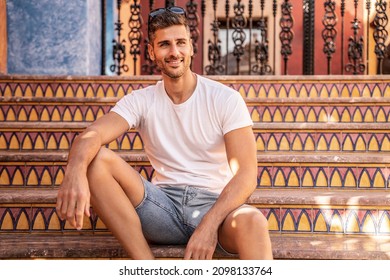 Smiling Handsome Italian Man Sitting On The Stairs, Relaxing. Fashionable Men. 