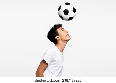 Smiling handsome teenage boy playing soccer, kicking ball with his head isolated on white background. Hobby concept - Powered by Shutterstock