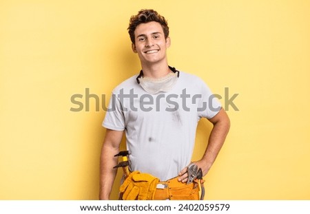 smiling happily with a hand on hip and confident, positive, proud and friendly attitude. handyman concept