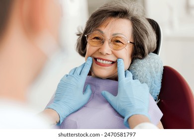 Smiling, happy, beautiful senior woman sitting in dental chair, dentist looking at teeth after treatment, whitening. Concept of dental care, health care - Powered by Shutterstock