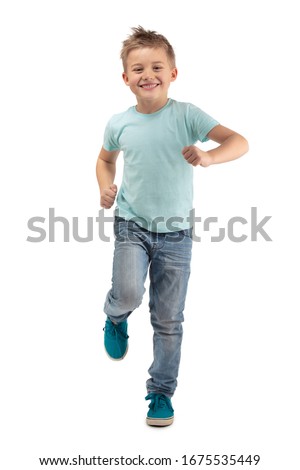 SMILING HAPPY BOY STANDING ON ONE LEG WHILE RUNNING ISOLATED ON WHITE BACKGROUND