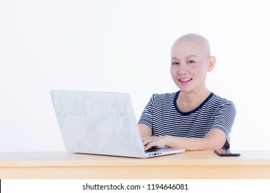 Smiling Happy Cancer Woman In Chemotherapy Period No Hair Working At Home With Technology,laptop, And Smartphone Look At Camera On Isolated Background