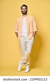 Smiling happy confident rich indian man standing isolated on yellow background. Happy handsome ethnic guy looking at camera advertising products posing for vertical full length portrait. - Shutterstock ID 2199901113