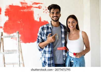 Smiling happy couple doing home renovation and holding key - Shutterstock ID 2077471795