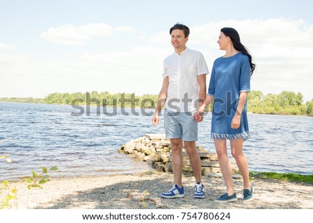 Smiling happy couple on sea. Couple in love, enjoying the summer time by the sea. Embrace the couple in love with the background of the river/sea.