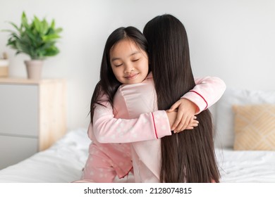 Smiling Happy Cute Korean Teen Girl In Pajama Hugging Young Lady In Bedroom Interior. Good Morning Together, Mothers Day Celebration At Home During Covid-19 Pandemic. Love And Relationship, Copy Space