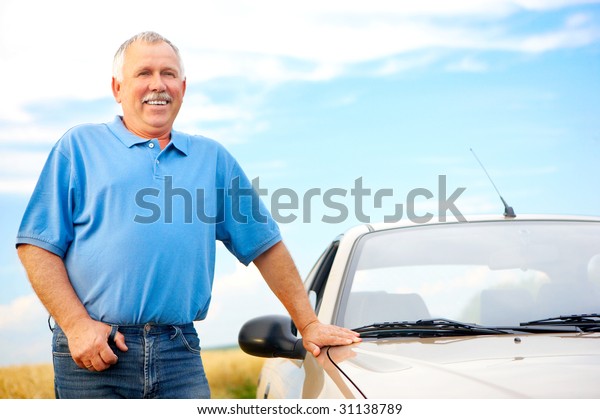 Smiling happy elderly\
man  and a new car