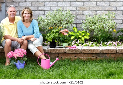 Smiling happy elderly seniors couple gardening near the home - Powered by Shutterstock