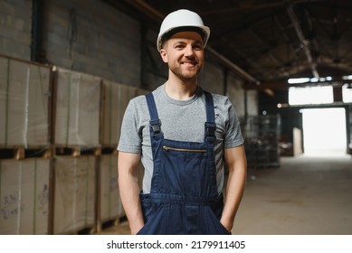 Smiling And Happy Employee. Industrial Worker Indoors In Factory. Young Technician With White Hard Hat