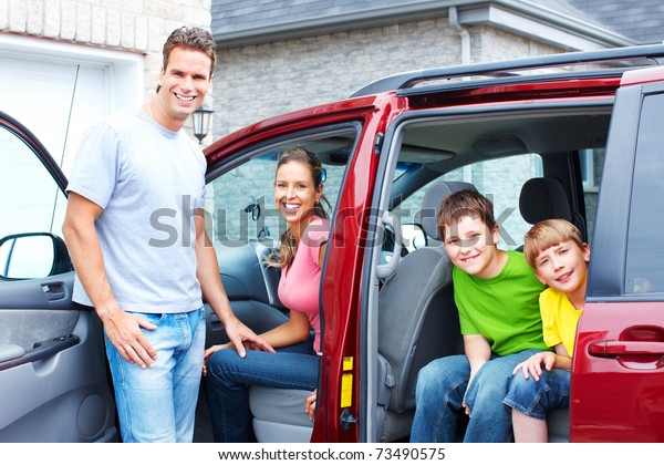 Smiling happy family and a\
family car.