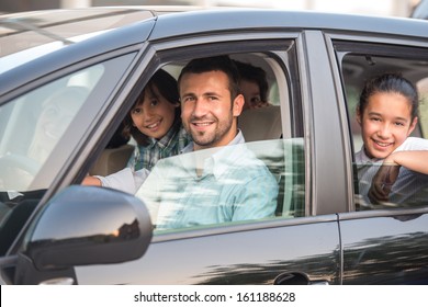 Smiling Happy Family Sitting In Car