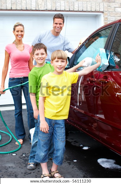 Smiling happy family\
washing the family car