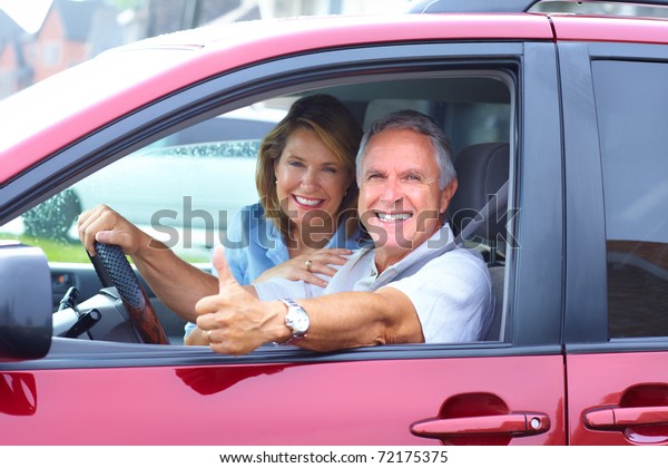 Smiling happy senior\
couple in the car