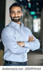Smiling happy successful ceo financial manager confident bearded indian businessman looking at camera standing with arms crossed. Handsome classy corporation owner. Vertical business portrait.