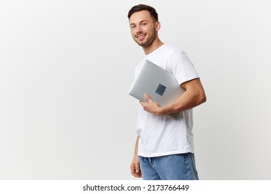 Smiling happy tanned handsome man in basic t-shirt hold laptop pc smile at camera posing isolated on over white studio background. Copy space Banner Mockup. Electronics repair concept - Shutterstock ID 2173766449