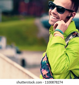 Smiling Happy Tourist Talking On Phone With Bluetooth Headset Device