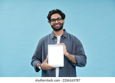 Smiling happy young arab man student showing digital tablet mockup screen presenting new online product, advertising web sale offer or website ads standing isolated on blue background. - Powered by Shutterstock