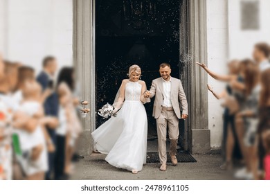 Smiling and happy young married couple leaving church after marriage. Launch of confetti, confetti and flower petals that are good wishes for marriage. - Powered by Shutterstock