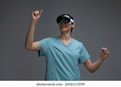 Smiling healthcare professional using her spatial computer headset, exploring the possibilities augmented reality in a medical context - Powered by Shutterstock