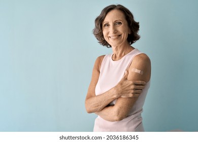 Smiling healthy mature older senior happy woman showing bandage on arm after getting vaccination. Vaccine and old elder people inoculation, elderly immunity for covid prevention concept. Portrait - Shutterstock ID 2036186345