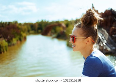 Smiling Healthy Solo Traveller Woman In Blue T-shirt On River Boat Exploring Countryside While Having River Cruise.