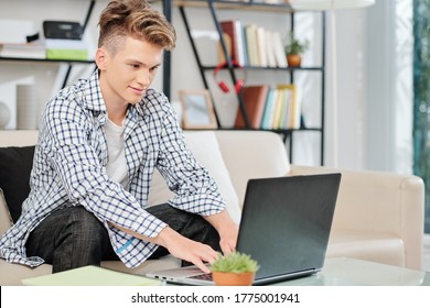 Smiling High School Student Doing Homework On Laptop At Home