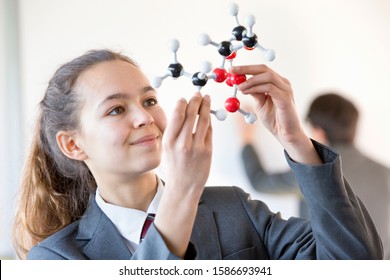 Smiling High School Student Examining Molecule Model In Science Class