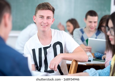 Smiling Highschool Boy Posing In Classroom