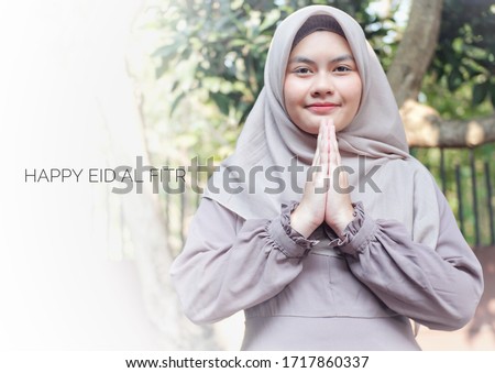 smiling hijab girl in greeting pose with several ramadan or eid al fitr caption, ramadan themed photo, ramadan greetings, eid al fitr greetings