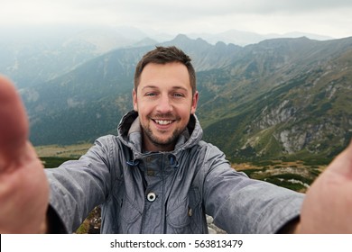 Smiling Hiker Taking A Selfie In Front Of Mountain Landscape