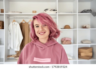 Smiling Hipster Gen Z Teen Girl Fashion Designer, Blogger With Pink Hair Piercing Wearing Hoodie Looking At Camera In Front Of Modern Clothes Wardrobe Closet, Face Head Shot Close Up Portrait.