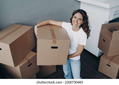 Smiling Hispanic Female Delivery Postal Service Worker Holding Packed Cardboard Box Preparing Parcels For Sending. Friendly Girl Employee Packing Cartons, Online Store Customer Orders In Storage Area.