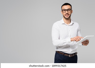 smiling hispanic manager in white shirt and eyeglasses using digital tablet isolated on grey - Powered by Shutterstock