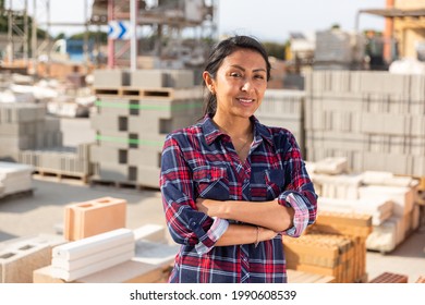 Smiling hispanic woman worker posing at building materials warehouse - Powered by Shutterstock