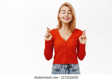 Smiling Hopeful Woman Cross Fingers And Wish, Praying, Anticipating Good News, Standing Over White Background