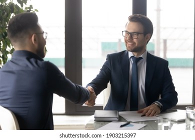 Smiling hr manager shaking hand of successful candidate after interview, Arabian man getting job, diverse business partners handshake, making great deal, agreement, employer greeting new employee