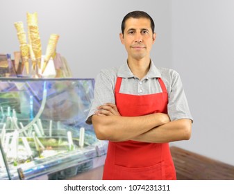 Smiling Ice Cream Store Employee Standing Behind The Counter In The Store With Crossed Arms 