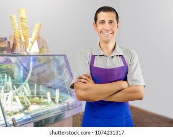 Smiling Ice Cream Store Employee Standing Behind The Counter In The Store With Crossed Arms