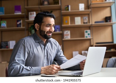 Smiling Indian Business Man Hr Employer, Teacher Or Lawyer Holding Cv Document Having Virtual Job Interview Meeting By Video Conference Call, Consulting Client On Laptop At Online Legal Advice.