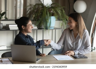 Smiling Indian And Caucasian Businesswomen Shaking Hands At Workplace In Office, Hr Manager Recruiter Greeting Successful Candidate At Job Interview, Manager Making Great Deal With Customer