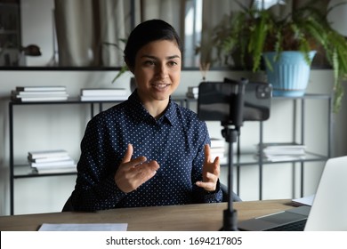 Smiling indian ethnic girl sitting in front of smartphone on stabilizer, recording self-presentation video or sharing professional skills. Happy young smart businesswoman filming educational lecture. - Shutterstock ID 1694217805