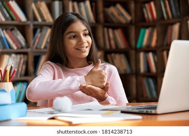 Smiling indian latin deaf disabled child school girl learning online class on laptop communicating with teacher by video conference call using sign language showing hand gesture during virtual lesson. - Shutterstock ID 1814238713