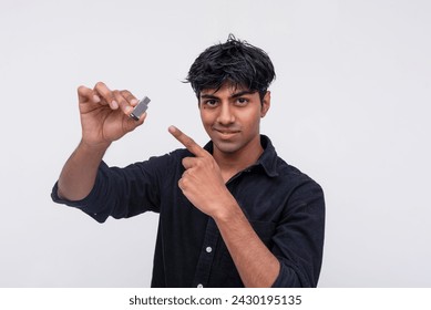 Smiling Indian man in a black shirt holding a USB flash drive, indicating it contains secret information and offline documents.