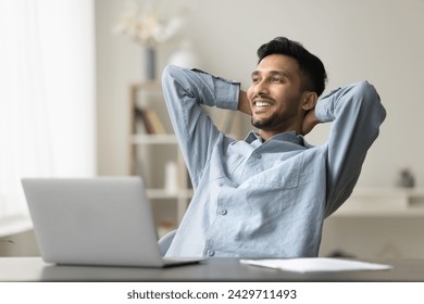 Smiling Indian man feeling satisfaction after work enjoy relaxation leaned on chair with hands behind head, finished project, make money on-line, take break, looking away. Aspirations, pause, good job - Powered by Shutterstock